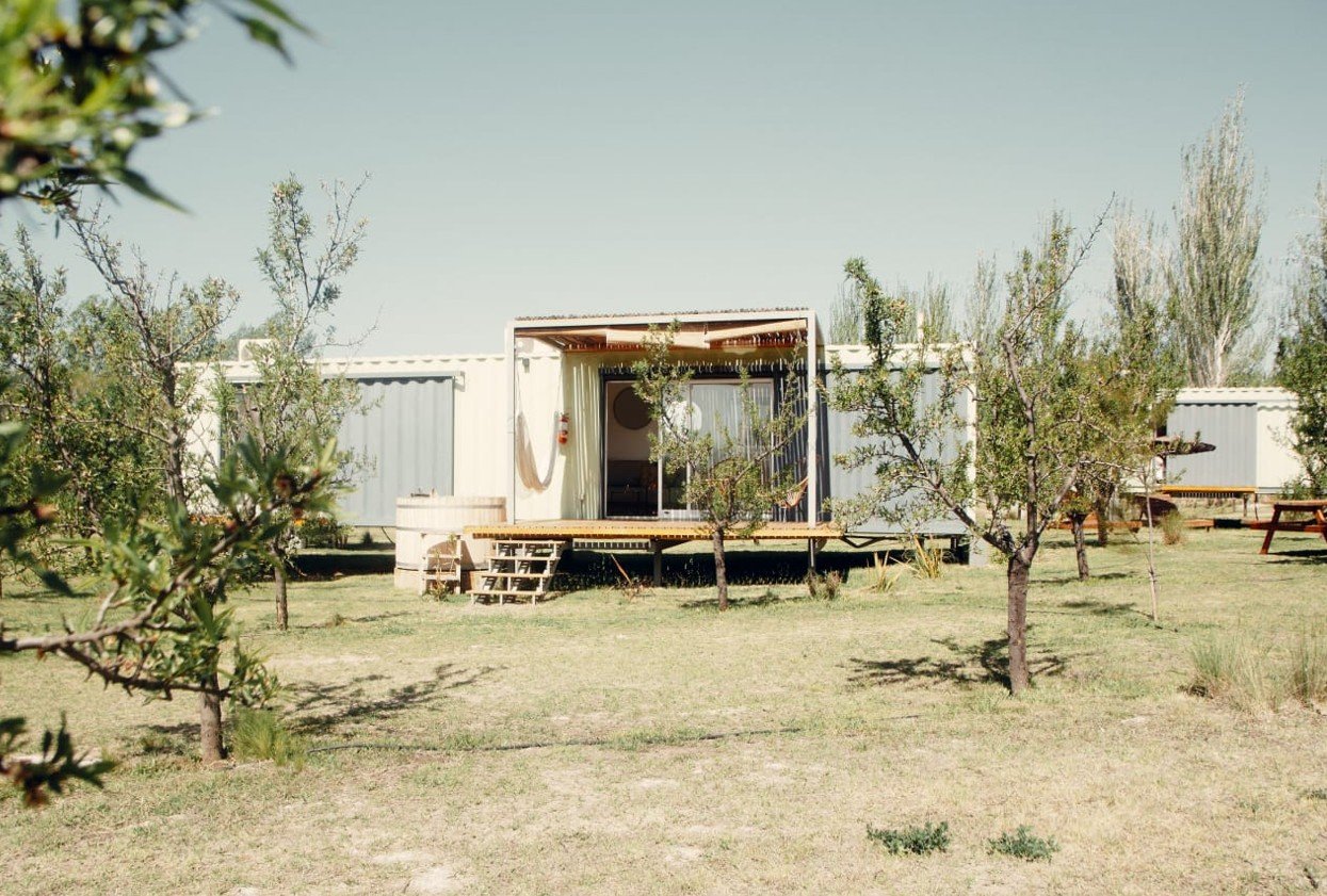 Vista general de la cabaña rodeada de árboles en Cabañas Las Guaras